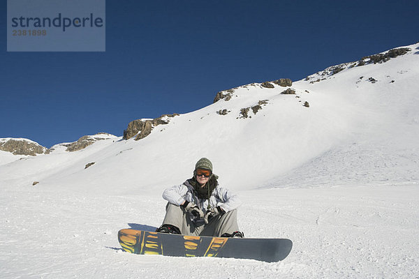Snowboarder auf Schnee sitzend