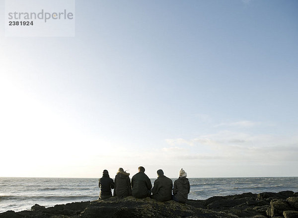 Gruppe von Freunden auf dem Felsen sitzend