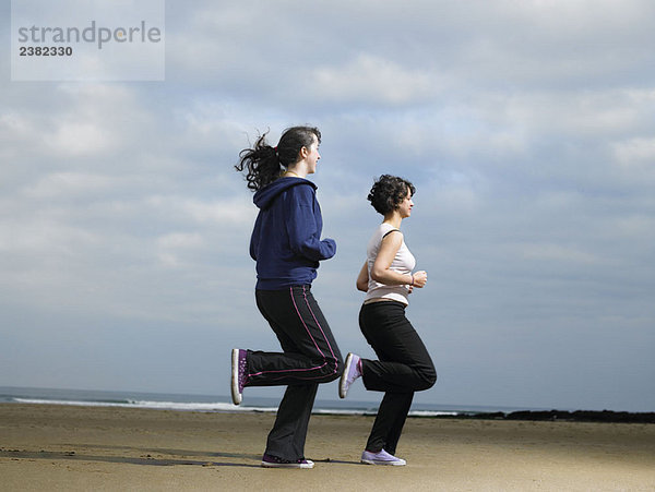 Zwei junge Frauen beim Joggen am Strand