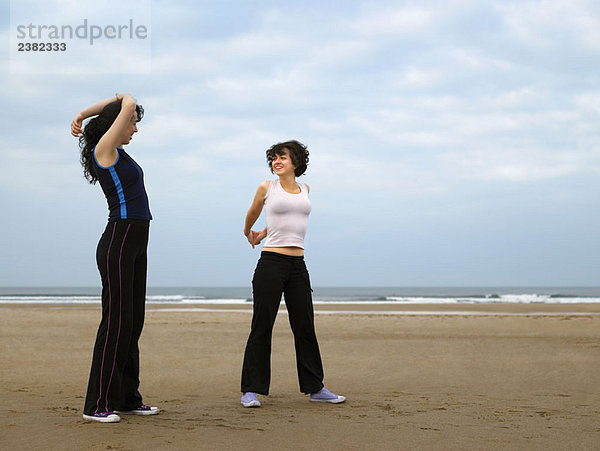 Zwei junge Weibchen  die sich am Strand ausstrecken.