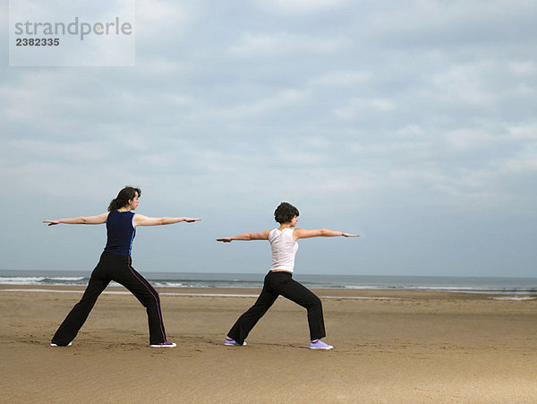 Zwei Frauen beim Yoga am Strand