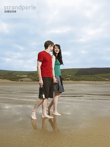 Junges Paar beim Spaziergang am Strand