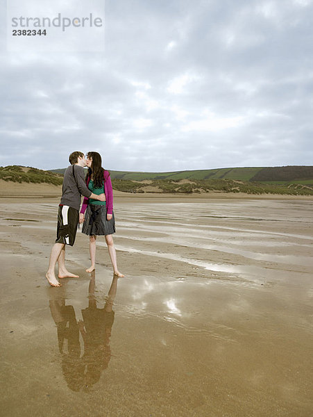 Junges Paar beim Küssen am Strand