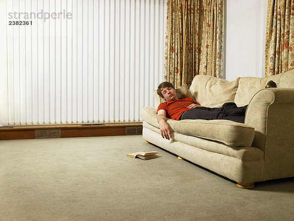 Mann schläft auf dem Sofa