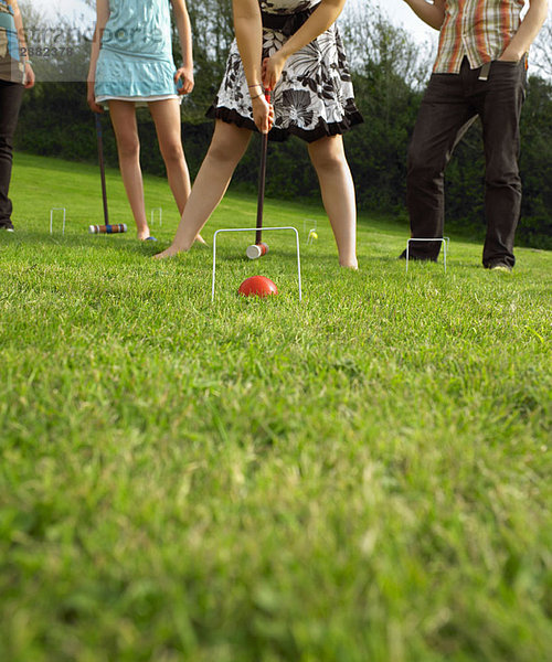 Mann und Frau beim Krocketspiel im Garten