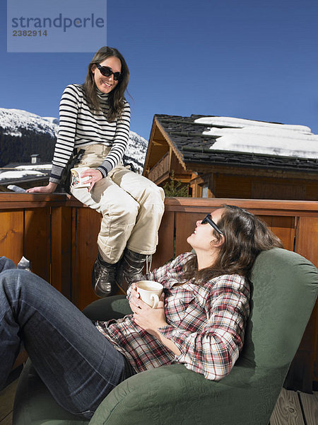 Junge Frauen beim Plaudern auf der Terrasse