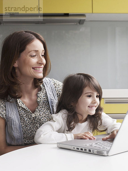 Mutter und junges Mädchen mit Laptop