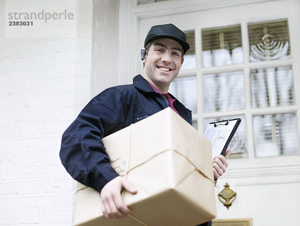 Kurier mit großem Paket an der Haustür