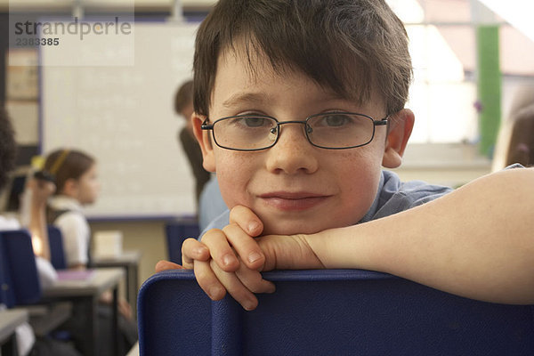 Junge schaut in die Kamera  im Klassenzimmer