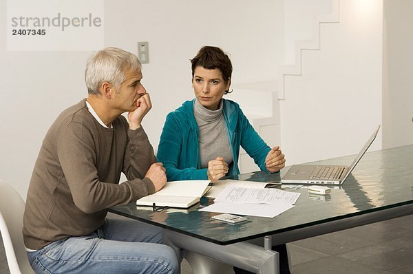 Ein reifer Mann und eine erwachsene Frau  die ihre Finanzen planen.