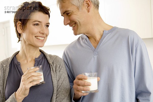 Ein reifer Mann und eine erwachsene Frau mit Milchgläsern.