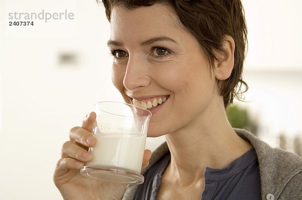 Nahaufnahme einer erwachsenen Frau  die ein Glas Milch trinkt.
