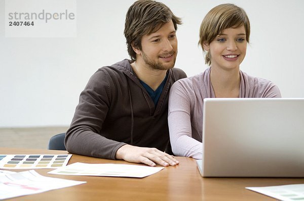 Mid Erwachsenen Mann und eine junge Frau mit einem Laptop und lächeln