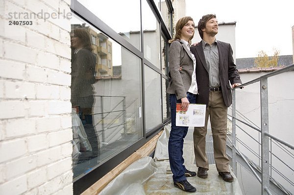 Mittlerer Erwachsener Mann und eine junge Frau  die auf einem Balkon stehen