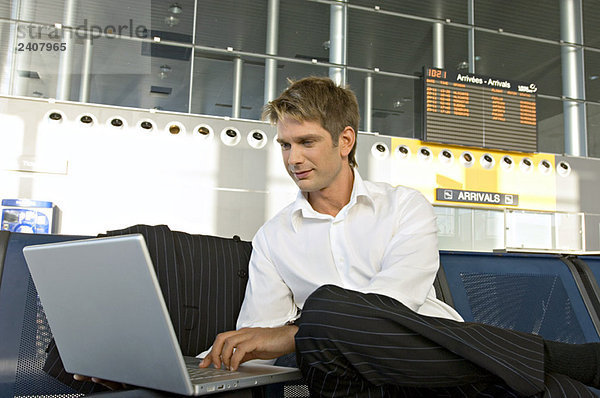 Geschäftsmann mit Laptop in einer Flughafenlounge