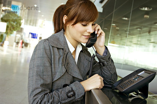 Nahaufnahme einer Geschäftsfrau am Telefon eines Flughafens