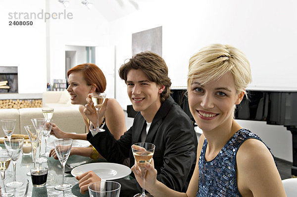 Zwei junge Frauen mit einem Teenager auf einer Dinnerparty