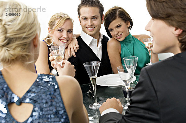 Fünf Personen genießen eine Dinnerparty