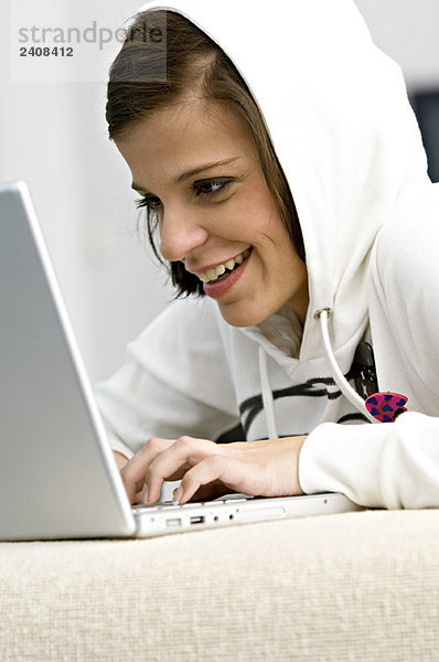 Seitenprofil einer jungen Frau mit Laptop und Lächeln