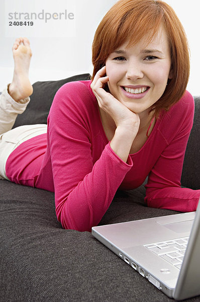 Porträt einer jungen Frau mit Laptop und Lächeln