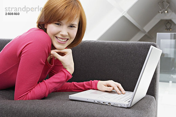 Porträt einer jungen Frau mit Laptop und Lächeln