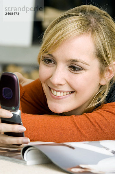Nahaufnahme einer jungen Frau mit dem Handy und lächelndem Gesicht