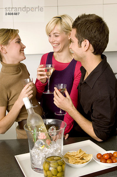 Zwei junge Frauen und ein junger Mann mit einer Martini-Brille.