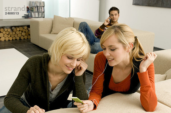 Zwei junge Frauen beim Hören eines MP3-Players
