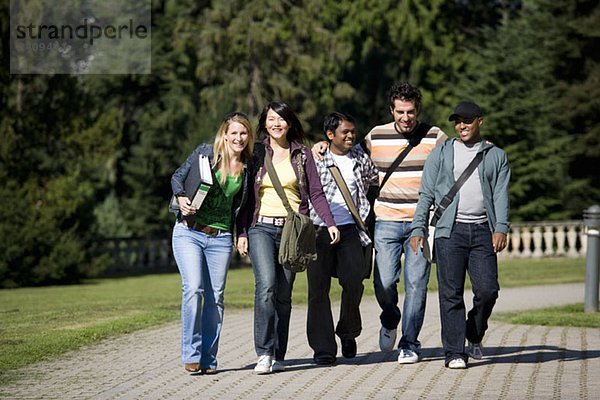 Studenten  die gemeinsam auf dem Campus spazieren gehen