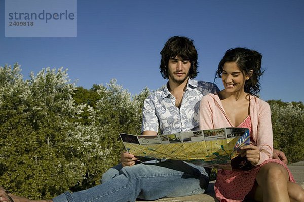 Ein junges Paar schaut auf eine Touristenkarte