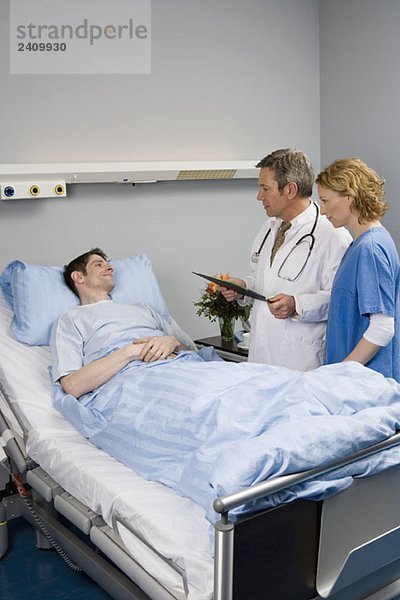 Zwei Mitarbeiter im Gesundheitswesen im Gespräch mit einem Patienten