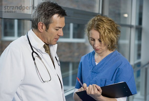 Zwei Gesundheitshelfer sprechen in einem Krankenhauskorridor