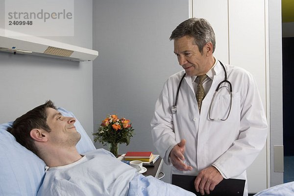 Ein Arzt im Gespräch mit einem Patienten im Krankenhaus