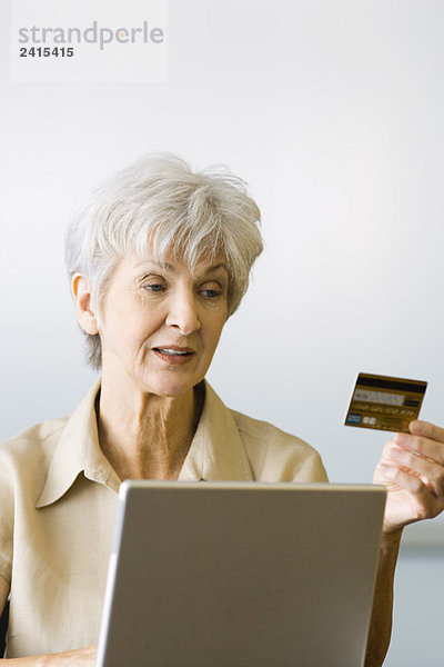 Senior Frau beim Online-Einkauf  Blick auf Kreditkarte