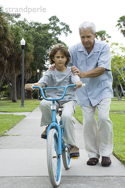 Großvater lehrt Junge Fahrrad fahren  volle Länge