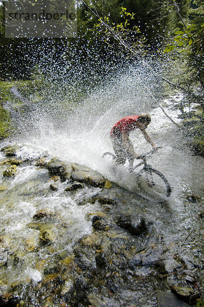 Mountainbiker überqueren einen Bach