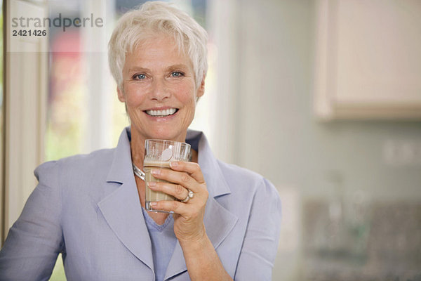 Frau hält Trinkglas  lächelnd  Portrait
