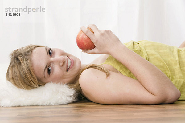 Blonde Frau hält einen Apfel  Portrait
