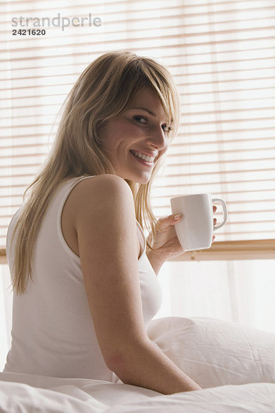 Blonde Frau mit einer Tasse Kaffee  lächelnd  Portrait