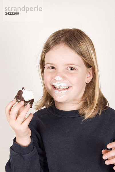Blondes Mädchen (8-9) mit einem Schoko-Marshmallow  Portrait