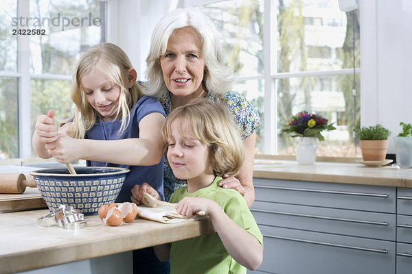 Großmutter und Enkelkinder (8-9) in der Küche