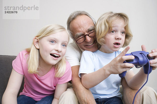 Großvater und Enkel (8-9) spielen Videospiel  Portrait