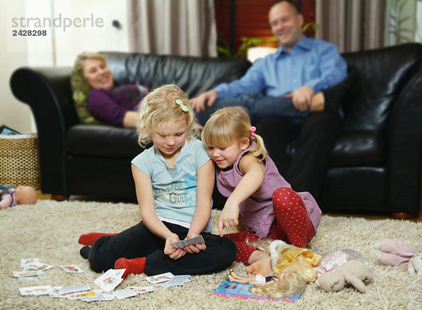 Kinder spielen Karten auf dem Boden