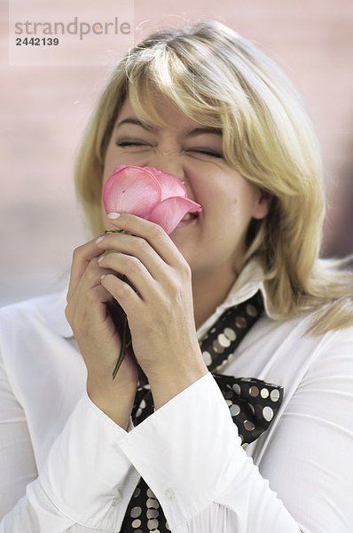 Nahaufnahme of Woman smelling rose