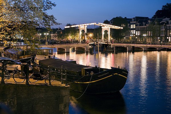 Zugbrücke über Fluss beleuchtet nachts  Magere Brug  Fluss Amstel  Amsterdam  Niederlande