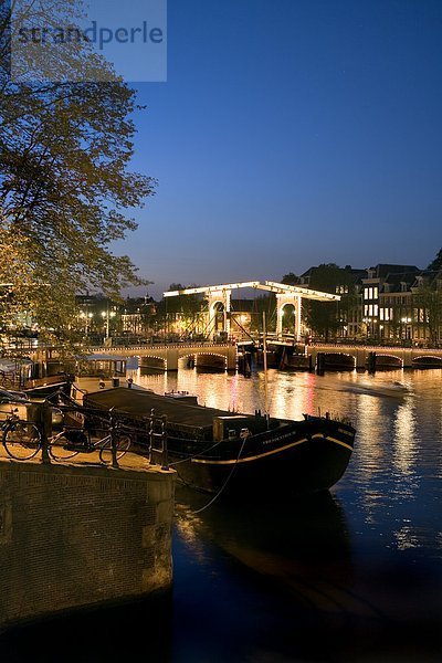 Zugbrücke über Fluss beleuchtet nachts  Magere Brug  Fluss Amstel  Amsterdam  Niederlande