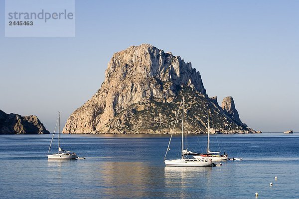 Segelboote im Meer mit Felsformation im Hintergrund  Es Vedra  Cala d ' Hort  Ibiza  Balearen Inseln  Spanien