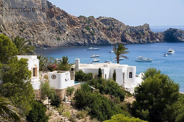 Gebäude an der K??ste mit Segelbooten im Meer  Cala Jondal  Ibiza  Balearen Inseln  Spanien