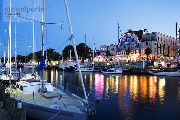 Segelboote in Fluss mit Gebäuden im Hintergrund  Rostock  Warnemunde  Mecklenburg-Vorpommern  Berlin  Deutschland