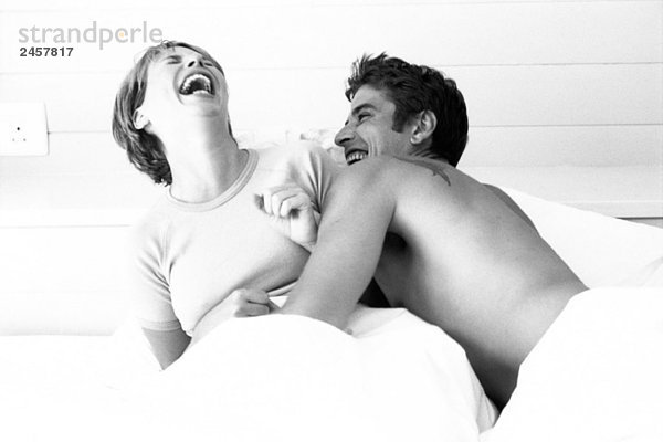 Paar im Bett  beide lachend